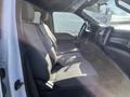 Interior view of a 2019 Ford F-350 SD showing front seats with gray upholstery and a dashboard with controls and displays