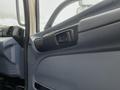 Interior view of a 2008 Hino Conventional Cab focusing on the door handle and controls with a blue and gray panel design