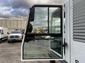 A side view of a 2007 Tennant Sentinel showing the open door with a glass window and a side mirror attached