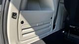 A storage compartment with a flat panel and horizontal grooves located inside a 2016 Dodge Grand Caravan