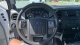 Interior view of a 2011 Ford F-450 SD showing the steering wheel dashboard controls and central console with audio system