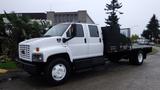 A white 2008 Chevrolet C7500 flatbed truck with a black rear cargo area and a cabin designed for multiple passengers