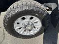 Close-up of a silver wheel with a textured black tire mounted on it showcasing rugged tread patterns