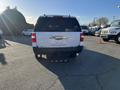 A white 2013 Ford Expedition parked with its rear facing the viewer showing the tailgate and rear bumper