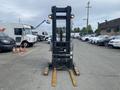 A 2004 Crown RR5210-35 stand-up forklift with a tall mast and wooden forks positioned upright facing forward