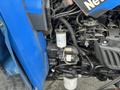 A close-up view of the engine components of a 2007 New Holland TN70A tractor showcasing various filters and hydraulic lines