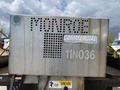A 2010 Ford F-550 with a metallic, perforated box mounted on the flatbed displaying the text Monroe Commercial and the number 11N036