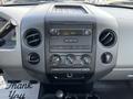 Dashboard of a 2008 Ford F-150 XL featuring audio controls ventilation knobs and a digital clock display