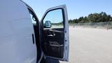 White 2012 GMC Savana van with an open driver's side door showcasing the interior and dashboard details