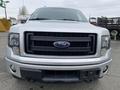 Front view of a silver 2014 Ford F-150 showcasing its distinctive grille and headlights