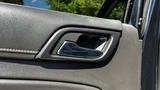 A close-up view of the door handle on a 2018 Chevrolet Tahoe's interior in a textured black material