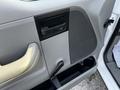 The interior door panel of a 2008 Ford F-150 XL featuring a handle speaker grill and a manual window crank