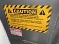 A caution sign on a 2021 Ford F-550 warning about hoist servicing and lubrication of grease fittings with instructions for bracing and dumping