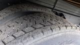 Close-up of two worn tires from a 2012 International TerraStar showing visible tread patterns and dirt accumulation