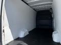 Empty interior of a 2022 Mercedes-Benz Sprinter van with a smooth black floor and white walls