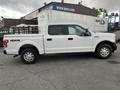 A white 2017 Ford F-150 with four doors and a short bed parked on a lot with a visible 4x4 emblem on the side