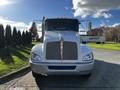 A white 2013 Kenworth T370 truck facing forward with a distinctive grille and orange clearance lights on the roof