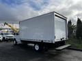 A white 2021 Ford Econoline box truck with a rear loading door and step at the back