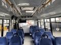 Interior of a 2018 Chevrolet Express with rows of blue padded seats and overhead lights