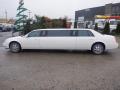 A white 2008 Cadillac Limousine with elongated body and five windows on each side, showcasing its luxury design and chrome wheels