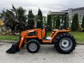 A 2001 Agco ST40 tractor with an orange and black body featuring a front loader and large rear wheels, parked on a concrete surface