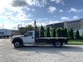 A 2013 Ford F-450 SD truck with a flatbed design parked on a lot showcasing its robust build and utility features