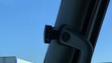 A black camera mounted on the interior of a vehicle's windshield near the driver's side A-pillar