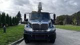 A blue 2009 International 4300 truck with a mounted equipment platform at the top facing forward