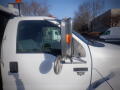 A white 2007 Ford F-650 featuring a side mirror and an orange marker light mounted on the roof