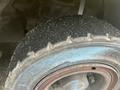 Close-up of a worn tire from a 2000 Hyster 120 forklift showing tread wear and a blue marking along the rim