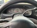 Close-up view of the steering wheel and dashboard of a 2001 Ford Econoline showing the speedometer and various gauges