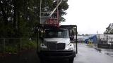 A 2010 International 4300 truck with a raised aerial platform marked 85 on the side