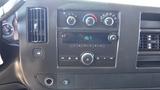 Dashboard controls of a 2012 GMC Savana featuring climate control knobs and a radio display with audio function buttons