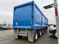 A blue 2011 Freightliner Cascadia Nordic truck with a large trailer and multiple wheels, positioned in a parking area