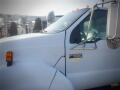 A 2007 Ford F-650 with a white exterior and orange marker lights on the cab showcasing its F-650 Super Duty badge