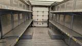 Interior of a 2006 Ford Econoline cargo van showing metal shelves on both sides and an empty floor space