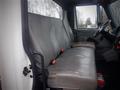 Interior view of a 2006 International 4300 truck showing two gray vinyl seats with seat belts and a steering wheel in the foreground