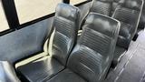 Interior seating of a 2014 Freightliner Thomas Diesel bus featuring several gray vinyl seats arranged in rows