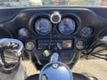 Close-up view of the dashboard of a 2004 Harley-Davidson Flhtcui featuring gauges, buttons, and a radio system