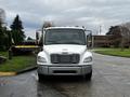 Front view of a white 2005 Freightliner M2 106 with a prominent grille and two side mirrors