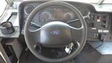 Interior view of a 2011 Ford Econoline dashboard featuring a steering wheel with a Ford emblem gauges and various controls