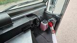 Interior view of a 2006 Ford Econoline showing the dashboard with controls and a fire extinguisher on the floor