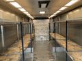 Interior of a 2005 Freightliner MT45 Chassis featuring metal shelving units along the sides and a flat floor