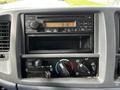 Dashboard panel of a 2006 Hino 268 featuring a CD player climate controls and an analog clock displaying the time