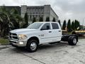 A white 2018 RAM 3500 truck with a crew cab and chassis, featuring chrome accents and clear headlights parked on a concrete surface