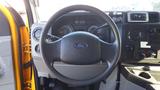 Steering wheel and dashboard of a 2015 Ford Econoline with gauges buttons and controls visible