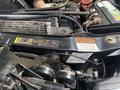 Close-up of the engine compartment of a 2010 Ford F-550 showing various components and a notice sticker on the engine cover