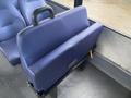 A blue padded seat back of a 2018 Chevrolet Express with a grab handle attached to it