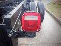 Close-up of a red taillight on a 2006 International 4300 truck with visible reflections and moisture on the surface