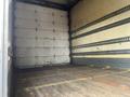 2008 Hino 268 truck interior with an empty cargo space featuring a wooden floor and metal tie-down rails on the walls